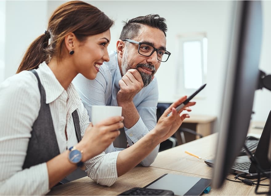 Office workers looking at the computer screen.